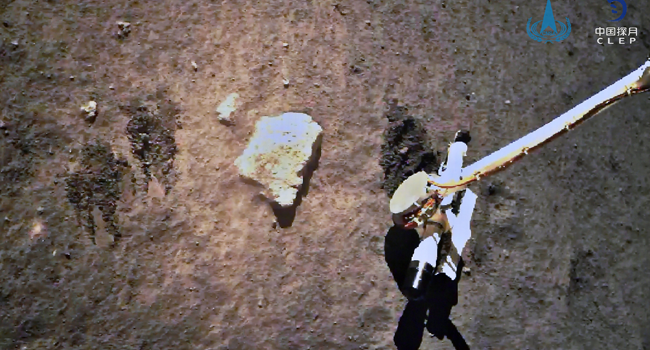 This picture taken on December 2, 2020 and released on December 3, 2020 by the China National Space Administration (CNSA) via CNS shows the Chang’e-5 lunar probe gathering samples on the moon. China National Space Administration (CNSA) via CNS / AFP