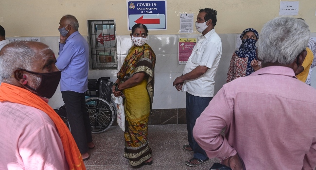 People stand in a queue at a Covid-19 vaccination centre amidst rising Covid-19 coronavirus cases, in Mumbai on April 8, 2021. INDRANIL MUKHERJEE / AFP